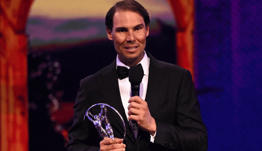 Rafael Nadal smiling while holding an award in his hand